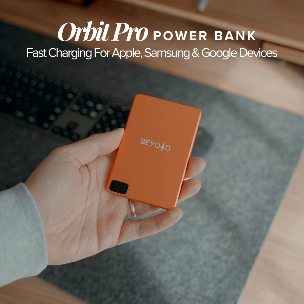 Orange power bank held in a hand with text 'Orbit Pro Power Bank' and 'BEYOND' branding.